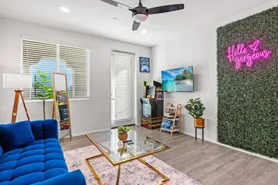 a living room with a blue couch and a glass table at Newly Remodeled 3BR Apt | Mins to Disney | Arcade in Placentia