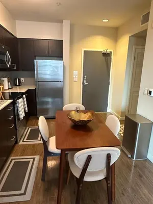 a kitchen with a wooden table and white chairs at Luxurious precious mile in Los Angeles