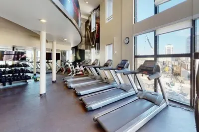 a gym with a row of treadmills and a large window at Luxurious precious mile in Los Angeles