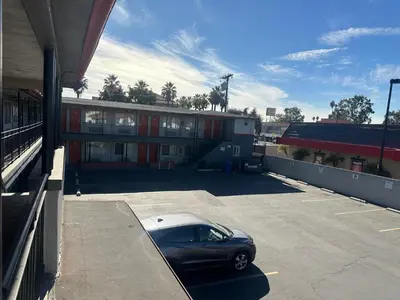 a car parked in a parking lot in front of a building at Heritage Inn in Pomona