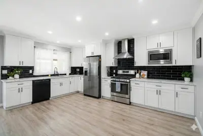 a kitchen with white cabinets and stainless steel appliances at Disney Frozen Fantasy by OC Adventure Homes in Garden Grove