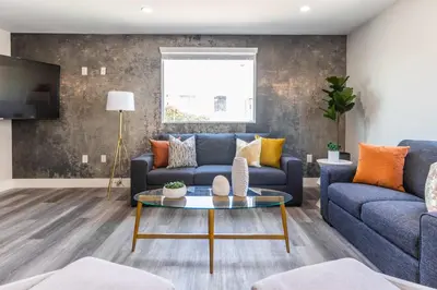 a living room with a blue couch and a table at Modern 4BR Stay Premium Beds & Full Kitchen in Burbank