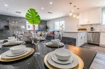 a dining room and kitchen with a table with wine glasses at Modern 4BR Stay Premium Beds & Full Kitchen in Burbank