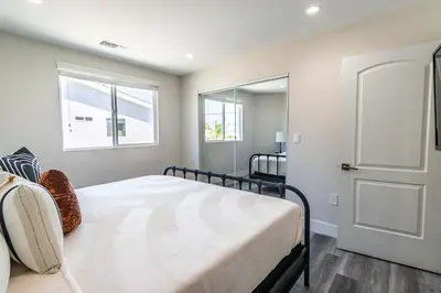 a bedroom with a bed and two windows at Modern 4BR Stay Premium Beds & Full Kitchen in Burbank