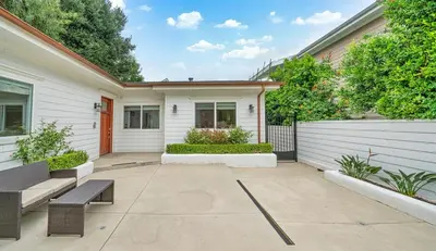 a patio with two benches in front of a house at Modern Luxe Villa Pool Rooftop Paradise in Sherman Oaks