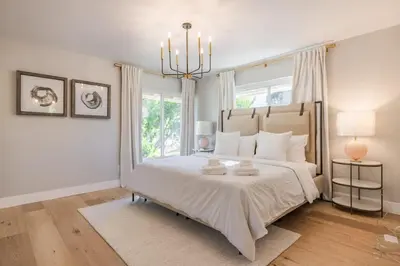 a bedroom with a large bed and a chandelier at Cozy Modern Haven w Soothing Ambience & Pool in Fullerton
