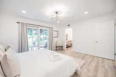 a white bedroom with a bed and a window at Marbella Lane - Serene Ranch Style Home wPool in Fullerton