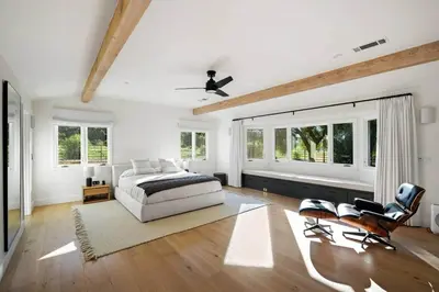 a bedroom with a bed and two chairs and windows at Ojai Valley - Pool and Pickle Ball in Ojai