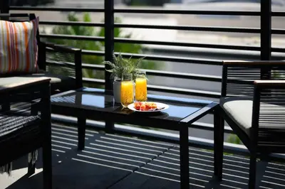 a table with a bowl of fruit and two glasses of orange juice at The Mandarin at Main Place - Free Disney Gift Gard in Orange