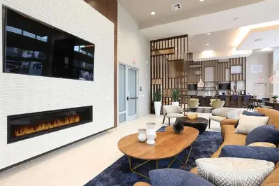 a living room with a fireplace and a couch at The Belladonna at Main Place - Disney Gift Card! in Orange