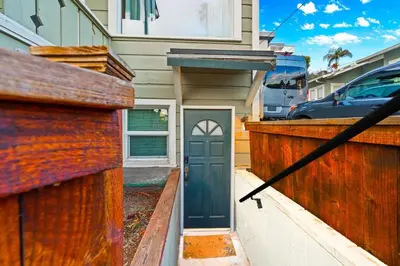 a house with a green door and a wooden fence at Netflix, Stocked Kitchenette, Beach Gear in Ventura