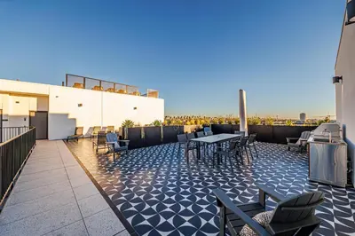 a rooftop patio with tables and chairs on a building at Luxury 1BD Condo in LA with Rooftop City Views, Gym & Free Parking in Los Angeles