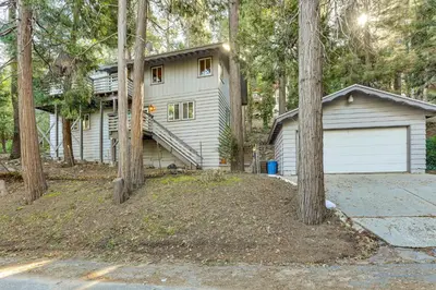 a white house with a garage and trees at Quiet Home Less Than 1 Mi to Lake Gregory and Dtwn Crestline in Crestline