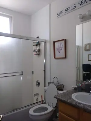 a bathroom with a toilet and a shower and a sink at Cozy Bungalow in Hewitt