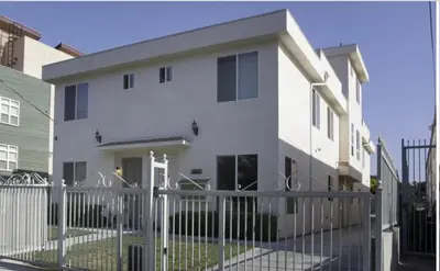 a white house with a fence in front of it at Cozy Bungalow in Hewitt