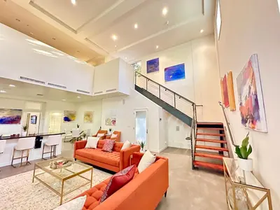 a living room with orange furniture and a staircase at The Gallery Spacious 2BD 2BA with Two King Beds in Los Angeles