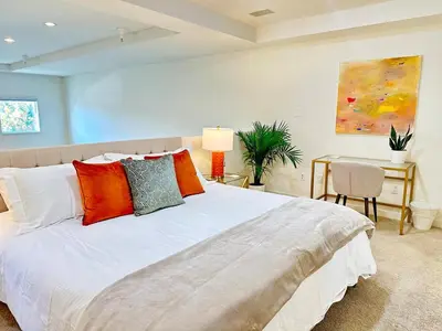 a bedroom with a large white bed with orange pillows at The Gallery Spacious 2BD 2BA with Two King Beds in Los Angeles