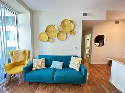 a living room with a blue couch and a yellow chair at 2 King Beds DTSM! Walk to Pier, Promenade & Beach in Los Angeles