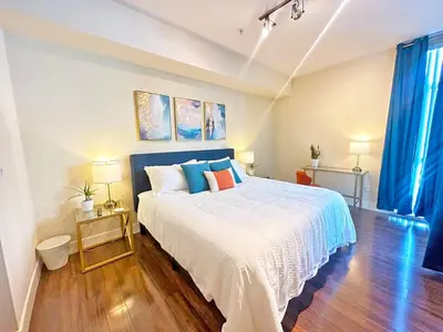 a bedroom with a large bed with blue curtains at Spacious 2 BD with 2 King Beds Walk to Pier & Beach in Los Angeles