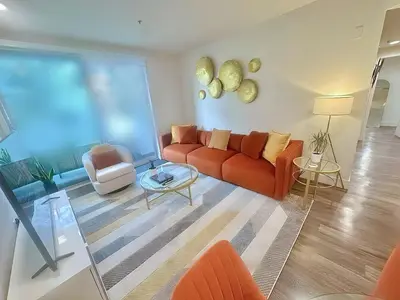 a living room with a red couch and two chairs at 2 KING BED SUITE WALK to BEACH,PIER, PROMENADE in Los Angeles