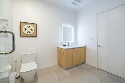 a bathroom with a toilet and a sink and a mirror at Marbella Lane - Sleek Corner Ocean View in Long Beach