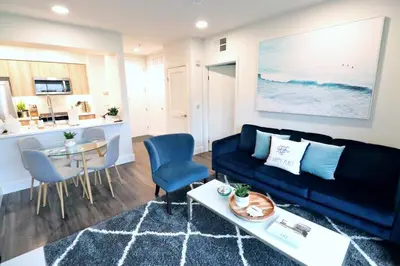 a living room with a black couch and a table at 2 KING BED LUXURY WALK to BEACH, PIER & PROMENADE in Los Angeles