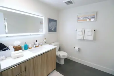 a white bathroom with a sink and a toilet at 2 KING BED LUXURY WALK to BEACH, PIER & PROMENADE in Los Angeles