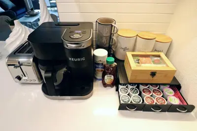 a coffee maker and a box of donuts on a counter at 2 KING BED LUXURY WALK to BEACH, PIER & PROMENADE in Los Angeles