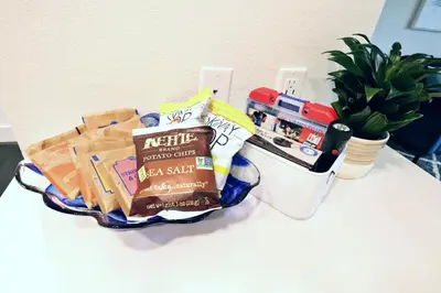 a table topped with a basket of food and snacks at 2 KING BED LUXURY WALK to BEACH, PIER & PROMENADE in Los Angeles