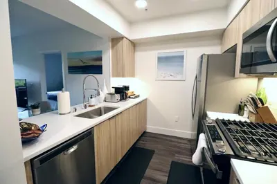 a small kitchen with a sink and a refrigerator at 2 KING BED LUXURY WALK to BEACH, PIER & PROMENADE in Los Angeles