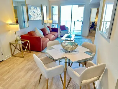 a living room with a table and chairs and a couch at 5 Star Location with City Views 2BD 2BA with King Beds in Los Angeles