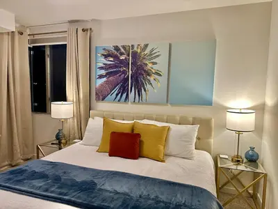 a bedroom with a large bed with two lamps at 5 Star Location with City Views 2BD 2BA with King Beds in Los Angeles
