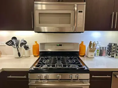 a kitchen with a stove with a microwave above it at 5 Star Location with City Views 2BD 2BA with King Beds in Los Angeles