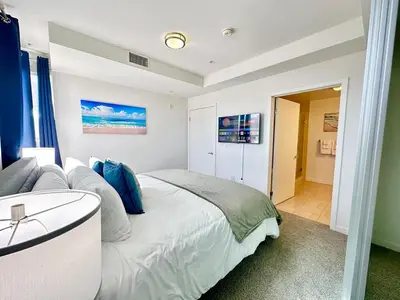 a bedroom with a large white bed with blue pillows at 5 Star Location with Open City Views 2BD 2BA with King Beds in Los Angeles
