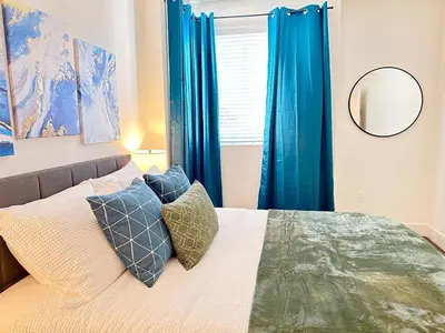a bedroom with a bed with blue curtains and a mirror at Bright 2 Bed 2 Bath with Views Walk to the Beach DTSM in Los Angeles
