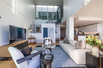 a living room with white furniture and a tv at Marbella Lane - Luxurious 3BR Penthouse in Long Beach