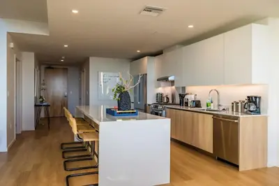 a kitchen with a counter and a kitchen island with chairs at Marbella Lane - Luxurious 3BR Penthouse in Long Beach