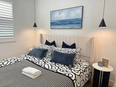 a bedroom with a large bed with blue and white pillows at Marbella Lane - Lovely DWNTN Getaway LongBeach in Long Beach