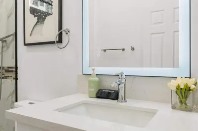 a bathroom sink with a mirror and a bottle of soap at Marbella Lane - Cityside Haven w Touch of Charm in Compton