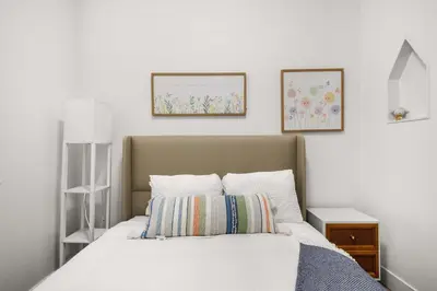 a bedroom with a bed and two pictures on the wall at Marbella Lane - Cityside Haven w Touch of Charm in Compton