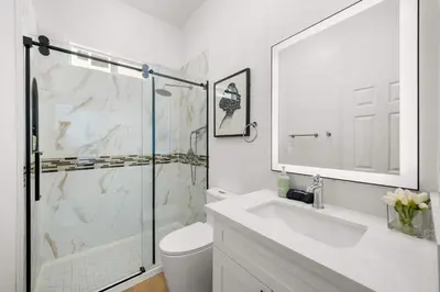 a white bathroom with a shower and a sink at Marbella Lane - Cityside Haven w Touch of Charm in Compton