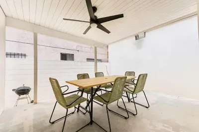 a table and chairs in a room with a ceiling fan at Marbella Lane - Cityside Haven w Touch of Charm in Compton