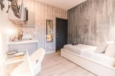 a bedroom with a white bed and a table at Cozy Private Studio, Private Entry in USC DPS Zone - DQA6 in Los Angeles