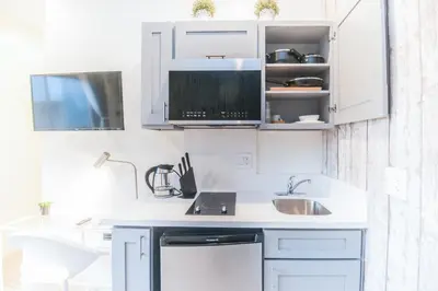 a kitchen with white cabinets and a sink at Cozy Private Studio, Private Entry in USC DPS Zone - DQA6 in Los Angeles