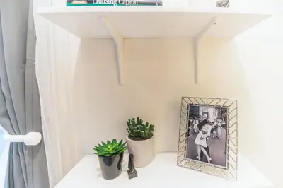 a shelf in a white room with plants and a picture at Cozy Private Studio, Private Entry in USC DPS Zone - DQA6 in Los Angeles