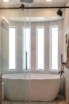 a bath tub in a bathroom with three windows at Moonstone Beach House Oceanview Luxe Retreat in Manhattan Beach