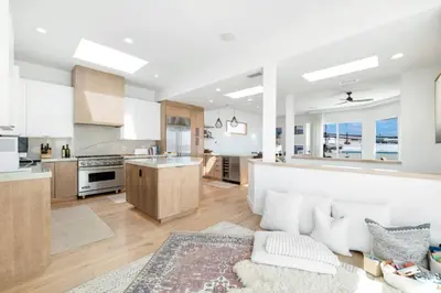 a kitchen and living room with a couch and a table at Moonstone Beach House Oceanview Luxe Retreat in Manhattan Beach