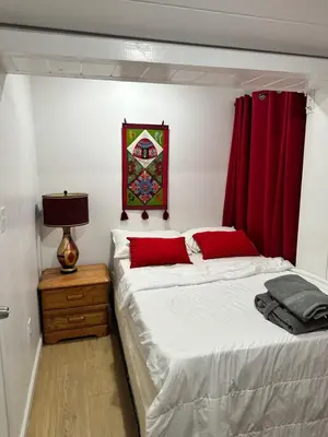 a bedroom with a large bed with red curtains at Naryn Guest House 3 in Los Angeles