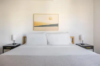 a bedroom with a white bed with two night stands at Blueground East Hollywood rooftop nr Griffith Park LAX-1335 in Los Angeles