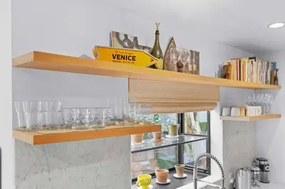 a shelf above a kitchen counter with glasses on it at New Listing Venice Villa by Colby & Conrad in Los Angeles